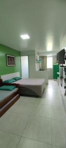 卡波布里奥Guest House Renascer K&W的一间卧室设有两张床和绿色的墙壁