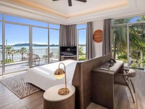 富国Premier Village Phu Quoc Resort Managed by Accor的一间卧室设有一张床,阳台配有电视。