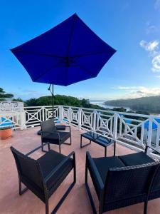 爱德华港Caribbean Estates Montego Bay 38的庭院配有三把椅子和蓝伞