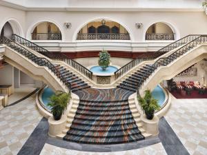 迪拜Mövenpick Hotel & Apartments Bur Dubai的螺旋楼梯,位于带大堂的大楼内