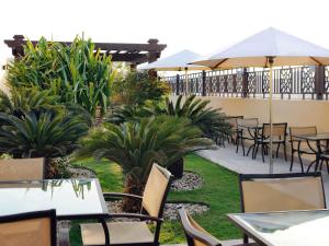 迪拜莫凡彼埃尔玛扎迪拜公寓式酒店的户外庭院设有桌椅和植物