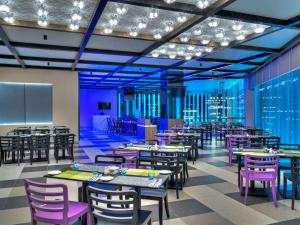 八打灵再也ibis PJCC Petaling Jaya的一间带桌子和紫色椅子的用餐室