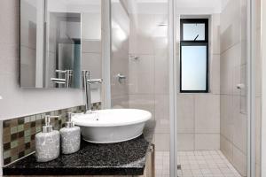约翰内斯堡Sunrise Rivonia One Bed的白色的浴室设有水槽和淋浴。