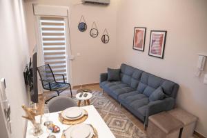 亚历山德鲁波利斯Ivi's Home Alexandroupoli的客厅配有蓝色的沙发和桌子