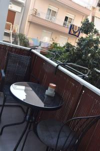 亚历山德鲁波利斯Ivi's Home Alexandroupoli的坐在阳台上的桌子上,喝杯咖啡