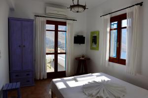 TholáriaTheoreion的卧室配有白色的床和窗户。