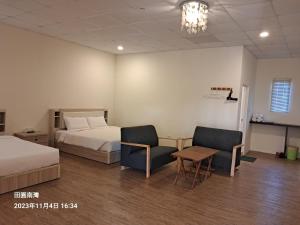 南湾田园南湾民宿 的酒店客房带两张床和一张桌子以及椅子。
