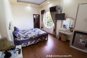 大叻Da Lat LUCINA Boutique Hotel的一间卧室设有一张床和一个大窗户