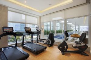 巴西利亚Windsor Brasilia Hotel的带有氧器材的健身房,位于带窗户的房间内