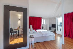 蒙特勒蒙特勒莎啦啦酒店的一间卧室配有一张带红色窗帘和镜子的床