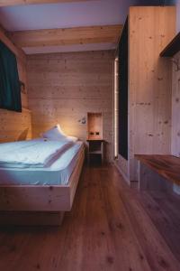 莫埃纳Hotel Zirmes的木制客房内的一间卧室,配有一张床
