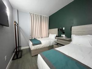 法拉盛Starlight Hotel的酒店客房设有两张床和窗户。