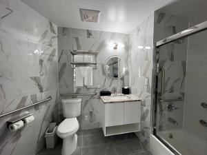 法拉盛Starlight Hotel的浴室配有卫生间、盥洗盆和淋浴。