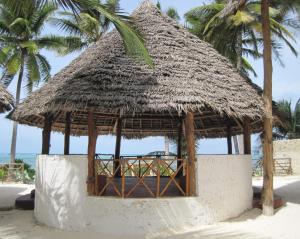 布韦朱Mjanaheri Beach Villas的海滩上带草屋顶的小屋