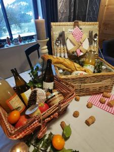 Saulxures-sur-MoselotteLa Ferme de Jean entre lacs et montagnes的一张桌子,上面有两篮子的食物和葡萄酒