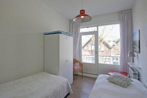 栋堡Residence de L'Europe - Baddomburg的一间卧室设有两张床和大窗户