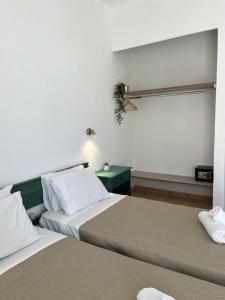 卡沃斯Meraki Kavos的一间卧室设有两张床和一张绿桌