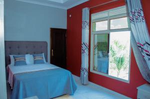 布琼布拉Kinindo Light Hotel的一间卧室设有一张床和一个窗口