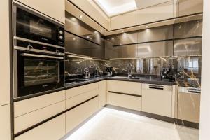莫奈姆瓦夏Vivian's Luxury Suite的厨房配有白色橱柜和黑色家电