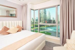 迪拜Elite Royal Apartment - Full Burj Khalifa & Fountain View - 2 Bedrooms + 1 Open Bedroom Without Partition - Magnate的一间卧室设有一张床和一个大窗户