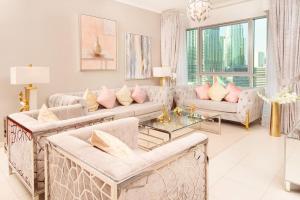 迪拜Elite Royal Apartment - Full Burj Khalifa & Fountain View - 2 Bedrooms + 1 Open Bedroom Without Partition - Magnate的客厅配有白色家具和粉红色枕头。