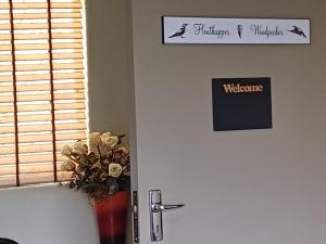 波切夫斯特鲁姆Tuiskoms & Toeka Guesthouse的带有迎宾标志和花瓶的门