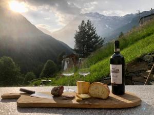 奇萨瓦玛兰科Baita Chalet La Masun beautiful view的一瓶葡萄酒和一些奶酪及酒杯