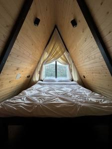 伯伊莱图什纳德Macko’s cabin的木制客房的一张床位,设有窗户