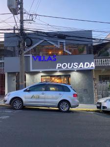 索罗卡巴Pousada Villas的停在商店前的银色汽车