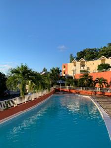 拉特里尼泰Sous les tropiques的棕榈树和建筑度假村的游泳池
