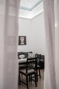 卡塔尼亚Ruggero Settimo - Holiday Houses的一间带桌椅和天花板的用餐室