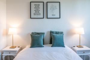 托马雷斯B&B ARENA SEVILLA的一间卧室配有两盏灯和一张带蓝色枕头的床。