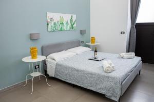 卡塔尼亚Ruggero Settimo - Holiday Houses的一间卧室配有床和两张带毛巾的桌子。