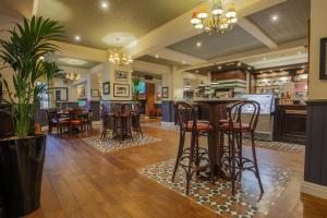曼彻斯特Fairway Inn的餐厅内的酒吧,配有桌椅