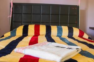 金贾Buvuma Island Beach Hotel的床上有五颜六色的毯子和毛巾