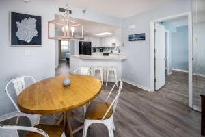 沃尔顿堡滩Nautilus 2609 Gulf View 2 Bedroom 6th Floor Free Beach Service的厨房以及带木桌和椅子的用餐室。