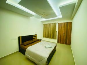 KazhakuttamAL-Kabeer Heights的一间白色客房内的床铺卧室