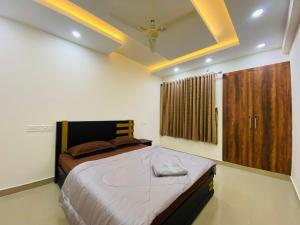 KazhakuttamAL-Kabeer Heights的一间卧室设有一张大床和一个窗户。