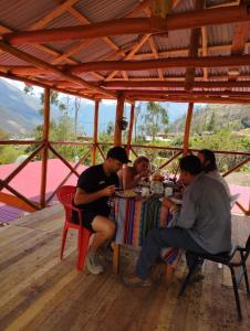 Cachorathe wooden house choquequirao的一群坐在餐桌上吃食物的人