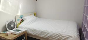 南京雅伦之屋 Yailon Aparment的一间卧室配有一张带风扇和一张桌子的床。