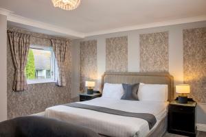 Langho福克斯菲尔德乡村酒店的一间卧室设有一张大床和一个窗户。