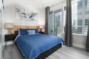 多伦多Simply Comfort Suites - One plus Den Apartment with Scotiabank Arena View的一间卧室设有蓝色的床和大窗户