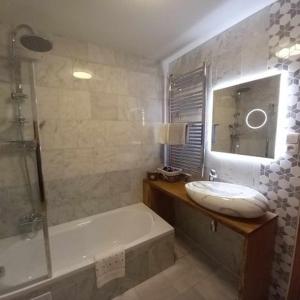 耶塞尼克Apartmány & Wellness Revenite的带浴缸、水槽和浴缸的浴室