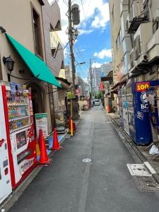 东京Lucky Hotel的一条空的街道,在建筑前有橙色锥