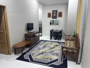 Kampung RajaWAJA Homestay的客厅配有电视、沙发和桌子