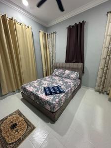 Kampung RajaWAJA Homestay的一间带床的卧室,位于带窗帘的房间