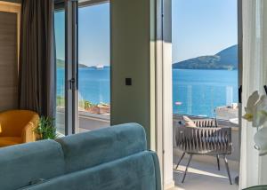 赫尔采格诺维Garni Hotel Kruso的客厅配有蓝色沙发,享有海景