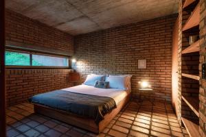 莫尔科泰Casa Brick by Quokka 360 - Luxury Design with Lake View的卧室配有砖墙内的床铺