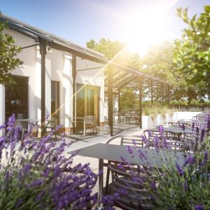 Langho福克斯菲尔德乡村酒店的一个带桌椅和紫色鲜花的庭院