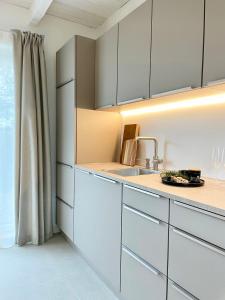 平讷贝格Cosy Concept - nahe Hamburg的厨房配有白色橱柜和水槽